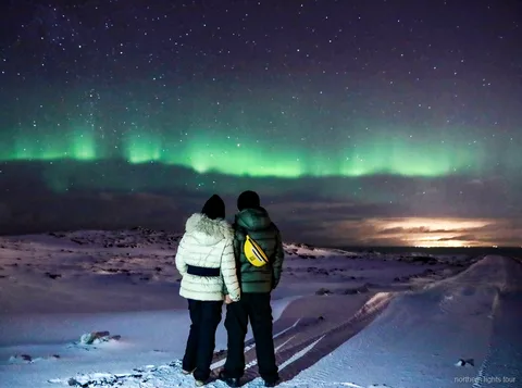 Viajeros tomando chocolate caliente en la excursión de auroras boreales en Reikiavik