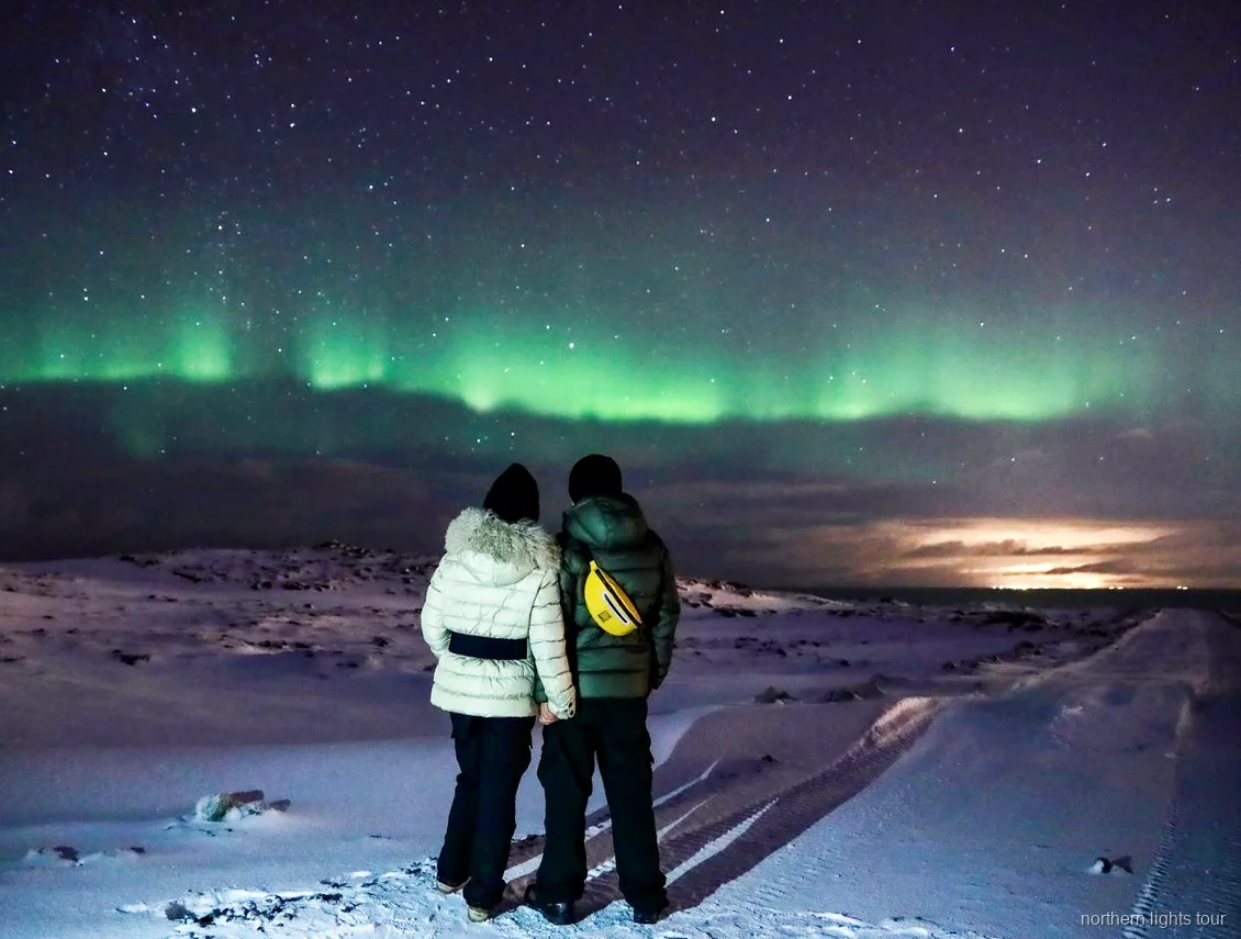 Gæster drikker varm kakao på Reykjavik nordlys-busturen