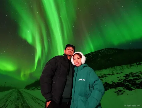 Grupp fotograferar norrskenet på Rovaniemi Norrsken Garanti-tur