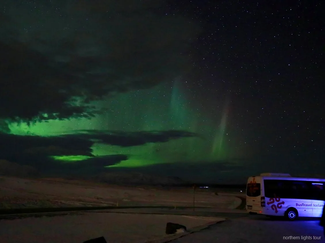Aurora boreal sobre a paisagem islandesa no tour premium de minibus em Reykjavik