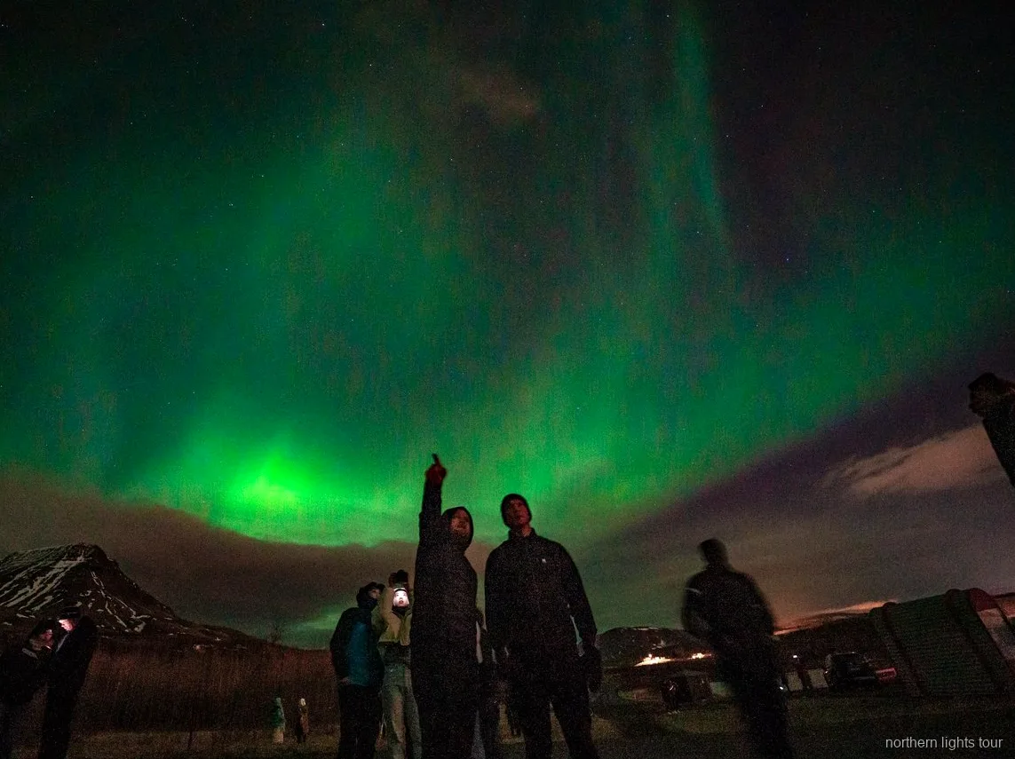 Viajantes a fotografar a aurora boreal no tour premium de minibus em Reykjavik