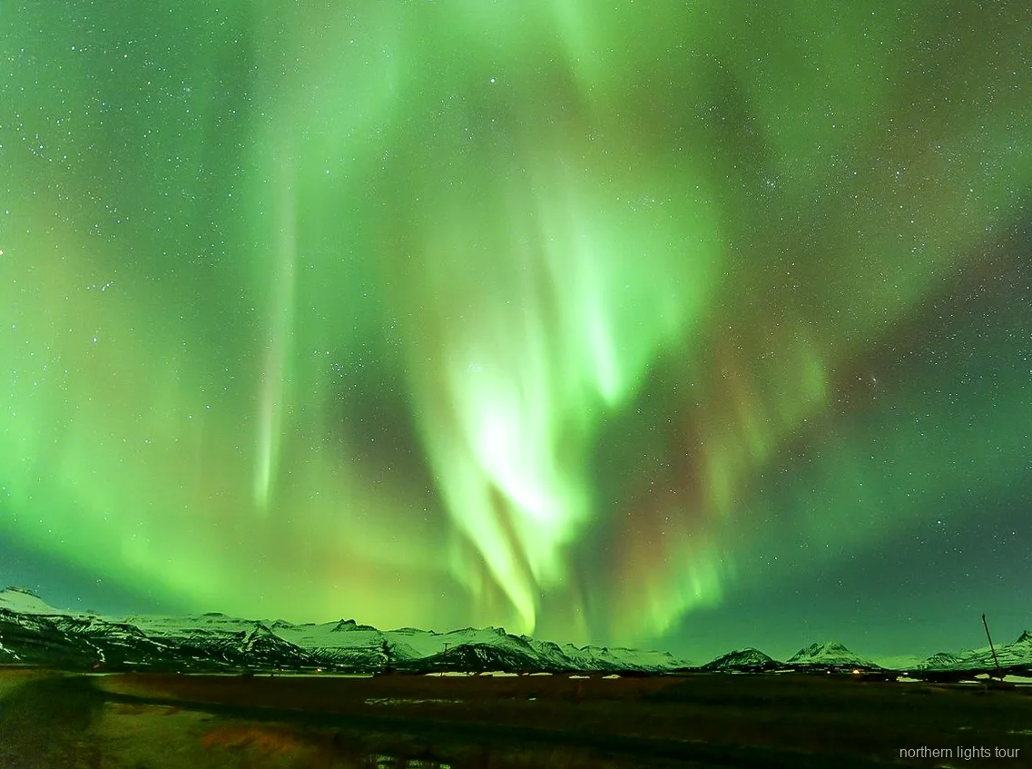 Guia a explicar a aurora boreal no minibus premium de Reykjavik