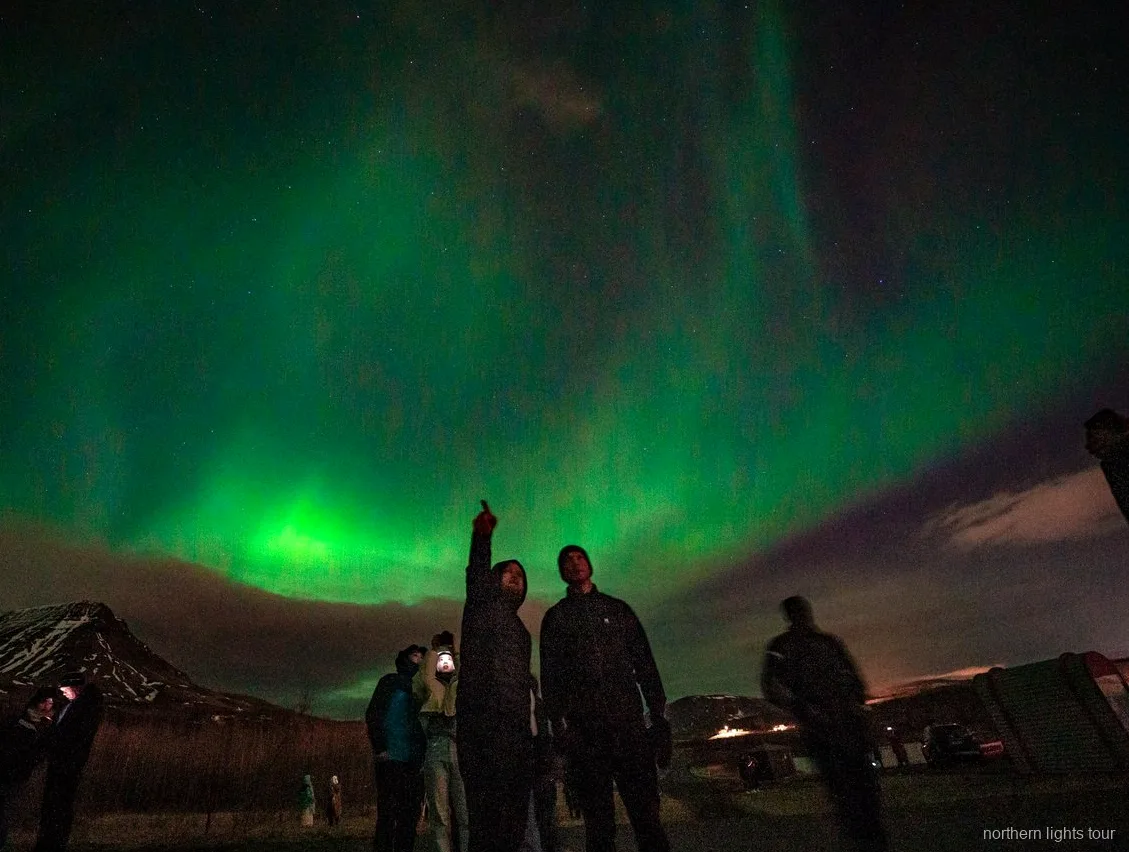 Hostes fotografiant l'aurora boreal al tour premium en minibús de Reykjavík