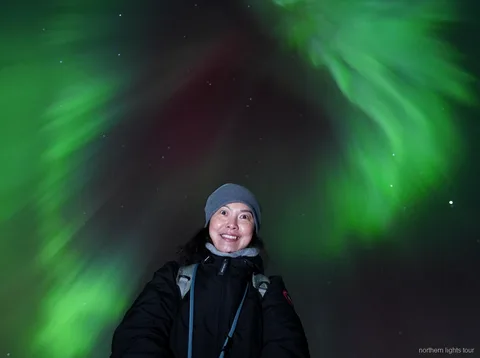 Aurora boreal sobre les muntanyes prop de Tromsø durant la cacera d'aurora