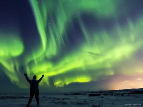 Pullman del tour aurora boreale Reykjavik parcheggiato in un punto di osservazione buio in campagna