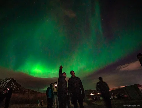 Ospiti che fotografano l'Aurora Boreale durante il tour in minibus Reykjavik premium