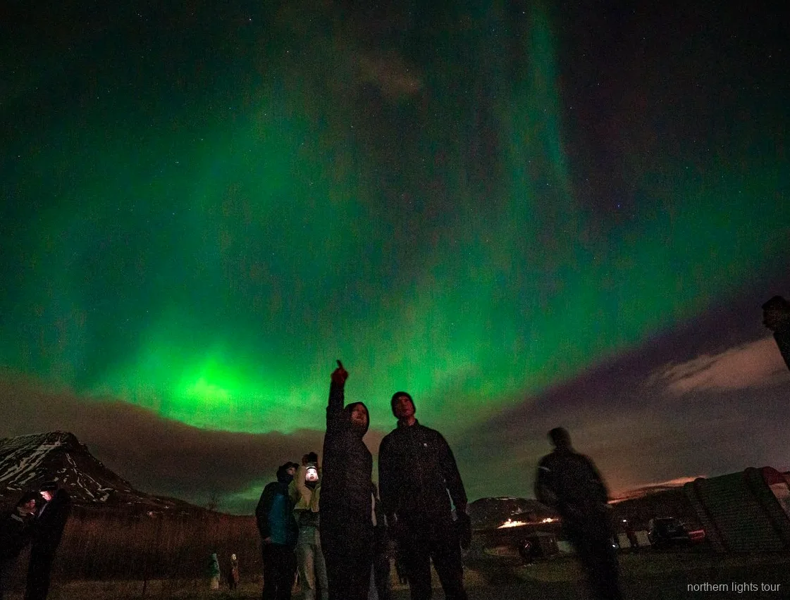 Ospiti che fotografano l'Aurora Boreale durante il tour in minibus Reykjavik premium