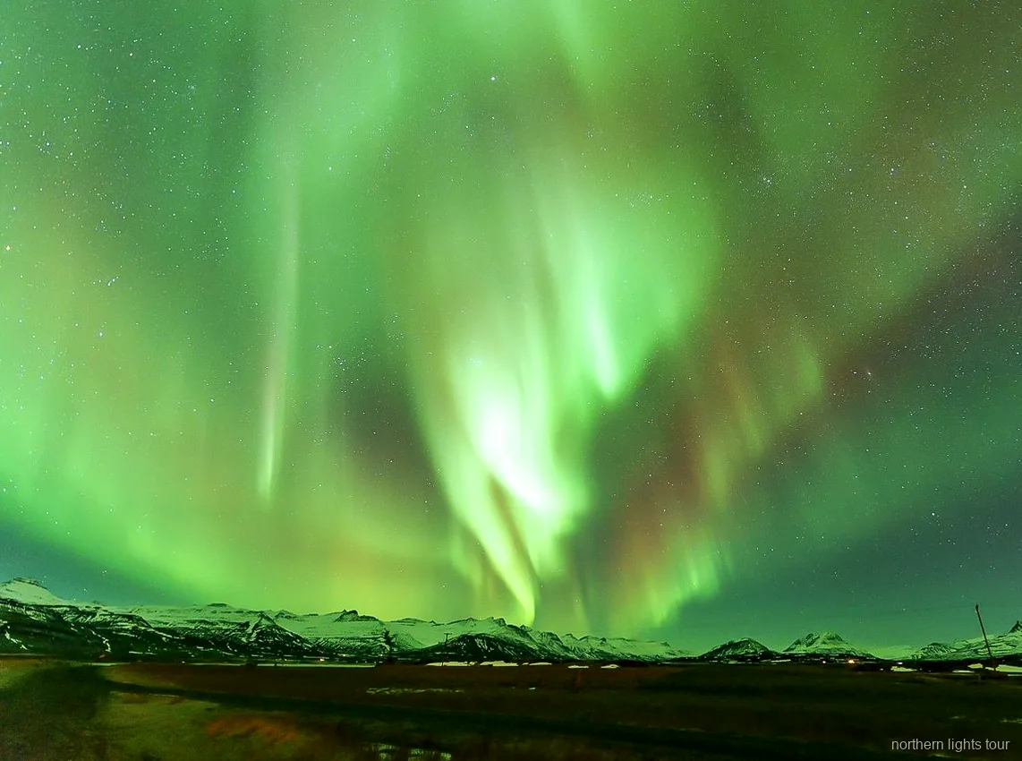 Guida che spiega l'Aurora Boreale durante il tour in minibus Reykjavik premium