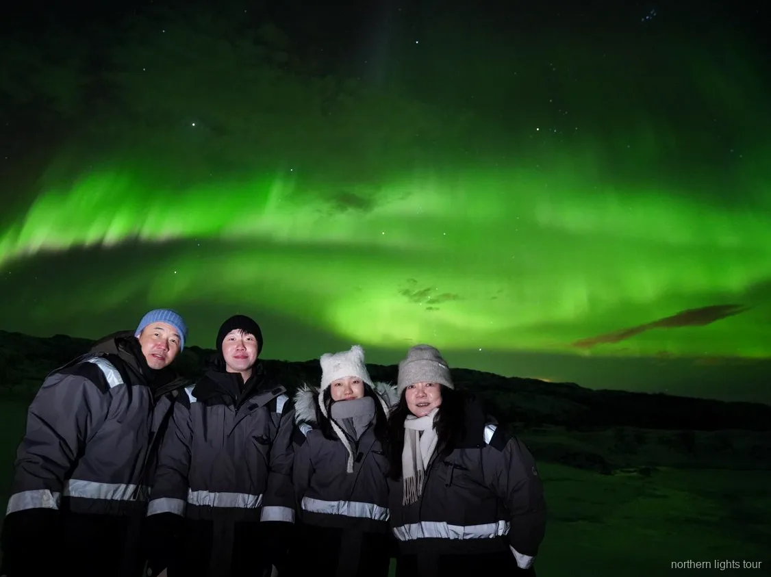 Ospiti avvolti in tute termiche a bordo del minibus del tour aurora boreale a Tromsø