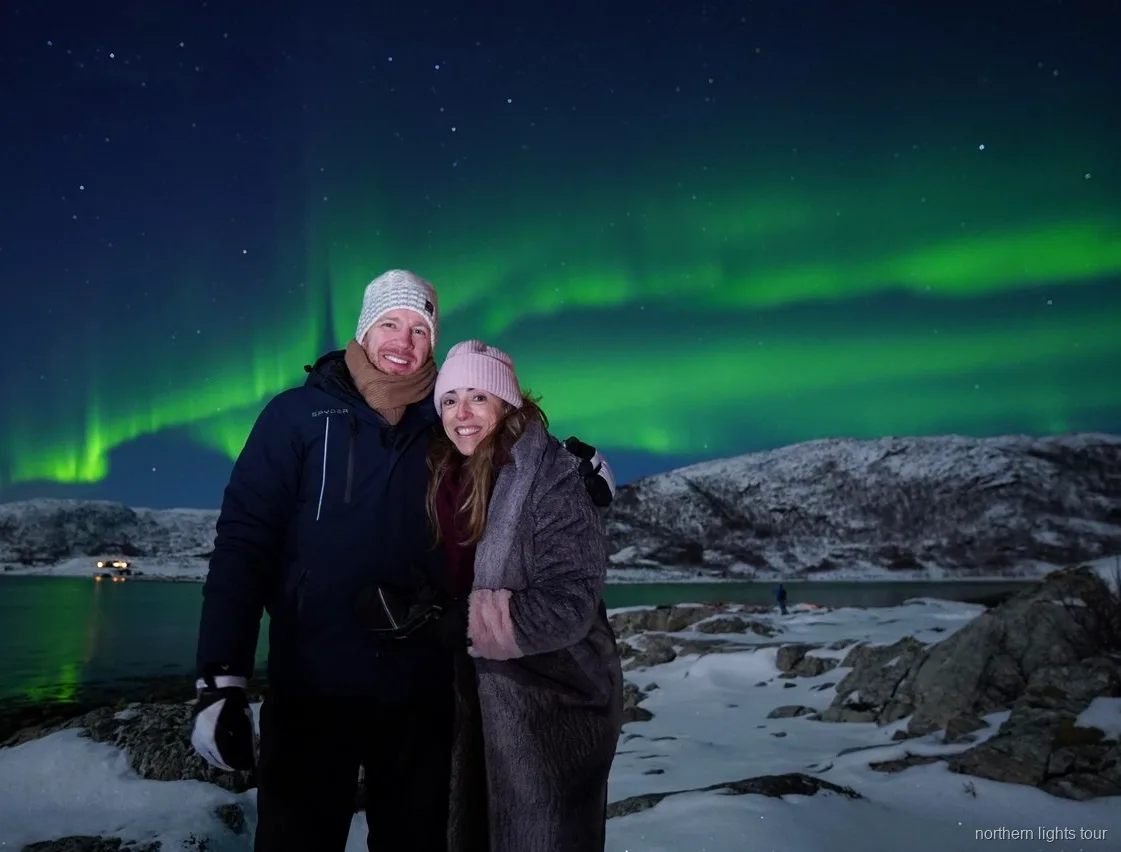 Grupo reducido observando la aurora boreal del tour de Tromsø desde un campamento junto al fiordo