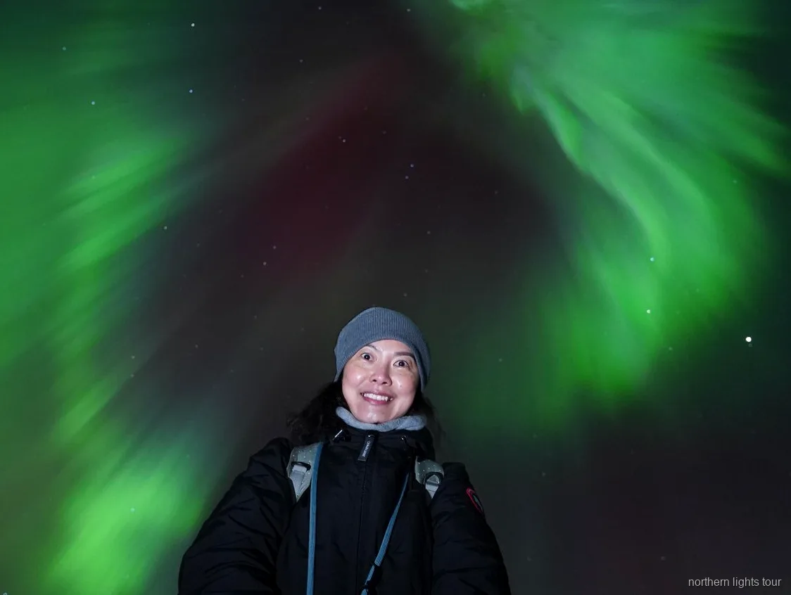 Aurora boreal sobre las montañas cerca de Tromsø durante el tour de caza de auroras