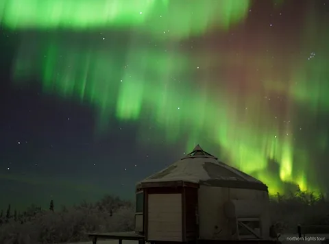 Gran ventanal orientado al norte dentro del refugio de auroras boreales de Alaska