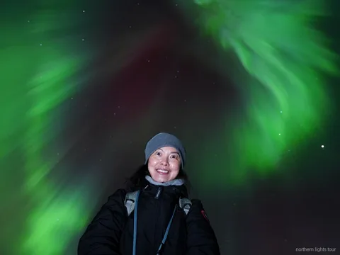 Noorderlicht boven de bergen nabij Tromsø tijdens de noorderlicht jacht tour