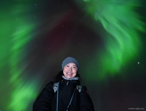 Aurora Borealis über den Bergen nahe Tromsø während der Nordlichter-Jagdtour