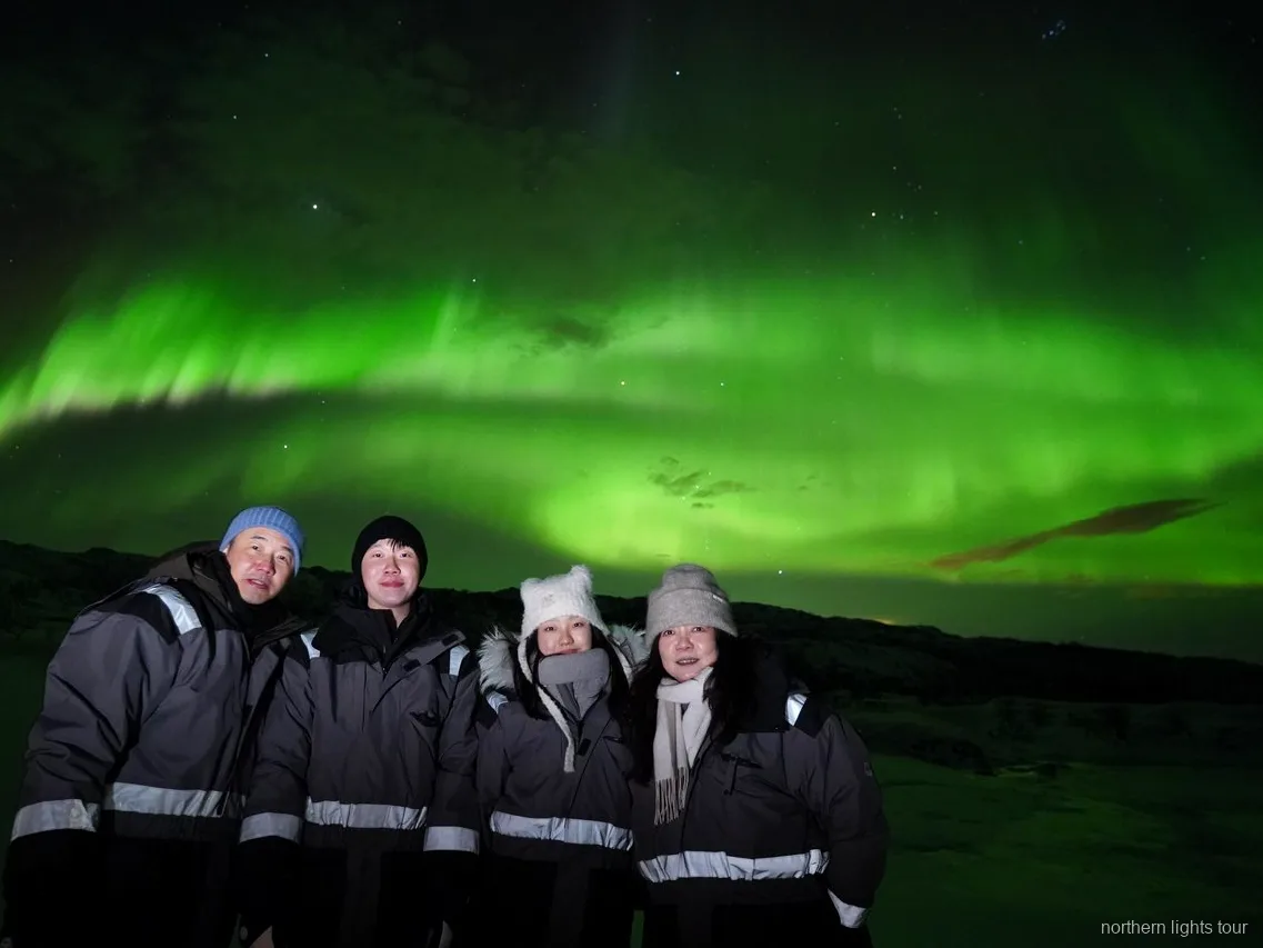 Gäste in Thermoanzügen auf der Tromsø Nordlichter-Jagd-Kleinbustour