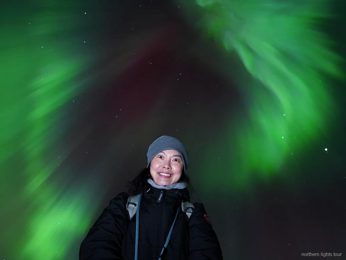 Nordlys over bjergene nær Tromsø under nordlysjagt-turen