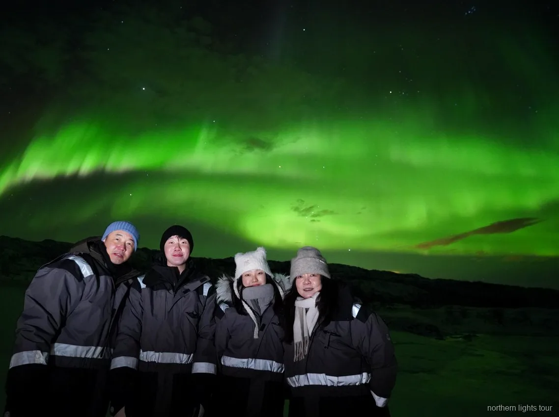 Guests wrapped in thermal suits on the Tromsø Northern Lights chase minibus tour